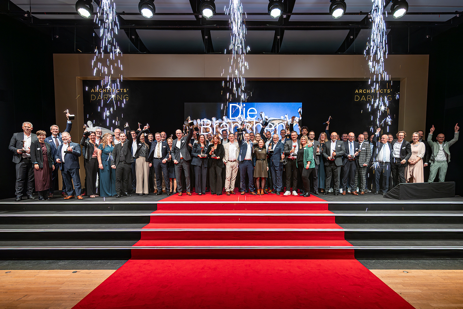 Stolze Siegerpose: Die Gewinner:innen der ARCHITECTS’ DARLING Awards 2025 mit der begehrten Phönix-Trophäe – Symbol für herausragende Leistung, Nachhaltigkeit und Bauqualität. Foto: (c) Marcus Jacobs, Heinze GmbH